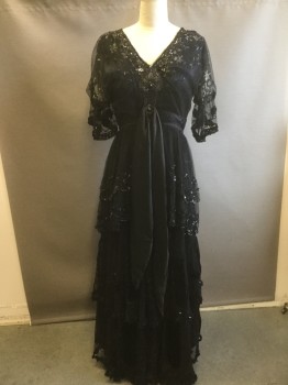 Womens, Evening Dress 1890s-1910s, MTO, Black, Beige, Sequins, Silk, Floral, W:34, B:38, Black Lace Dress with Beading and Sequins Throughout, Beige Floral Embroidery, V-neck, Puffed Sleeve with Wide Ruffle and Velvet Floral Appliqués, Satin Sash Drapes From Waist and Beaded Appliqués, Ruffled Lace Tiers on Skirt with Sequins, Silk and Velvet Under Layer at Hem,