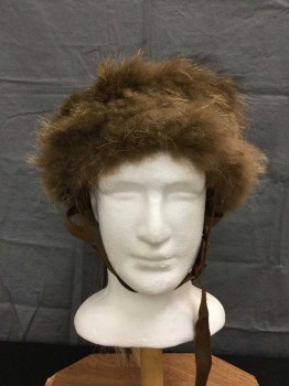 Unisex, Historical Fiction Headpiece, M.T.O., Brown, Gray, Brass Metallic, Black, Cream, Leather, Fur, 23.5", Mongolian Hat/ Helmet. Worn Brown Leather Hat with Brown Fur Hat Band & Gray Rabbit Fur Panels with Brass Studs and Findings. Black & Cream Horsehair Tail At Top Of Crown. Brown Leather Adjustable Chin Strap with Buckle