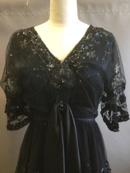 MTO, Black, Beige, Sequins, Silk, Floral, Black Lace Dress with Beading and Sequins Throughout, Beige Floral Embroidery, V-neck, Puffed Sleeve with Wide Ruffle and Velvet Floral Appliqués, Satin Sash Drapes From Waist and Beaded Appliqués, Ruffled Lace Tiers on Skirt with Sequins, Silk and Velvet Under Layer at Hem,