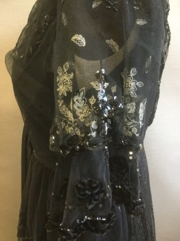 MTO, Black, Beige, Sequins, Silk, Floral, Black Lace Dress with Beading and Sequins Throughout, Beige Floral Embroidery, V-neck, Puffed Sleeve with Wide Ruffle and Velvet Floral Appliqués, Satin Sash Drapes From Waist and Beaded Appliqués, Ruffled Lace Tiers on Skirt with Sequins, Silk and Velvet Under Layer at Hem,