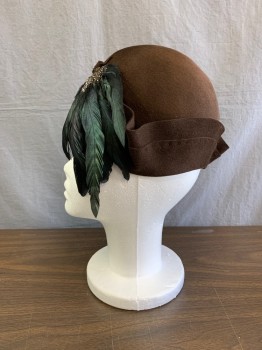 Broadway New York, Brown, Wool, Feathers, Solid, Cloch Style Felt with Double Layer Upturned Brim Detail , Small Matching Felt Knot with Small Blk and Wht Speckled Pheasant ,and a Downward Spray of Iridescent  Green Coque Feathers .